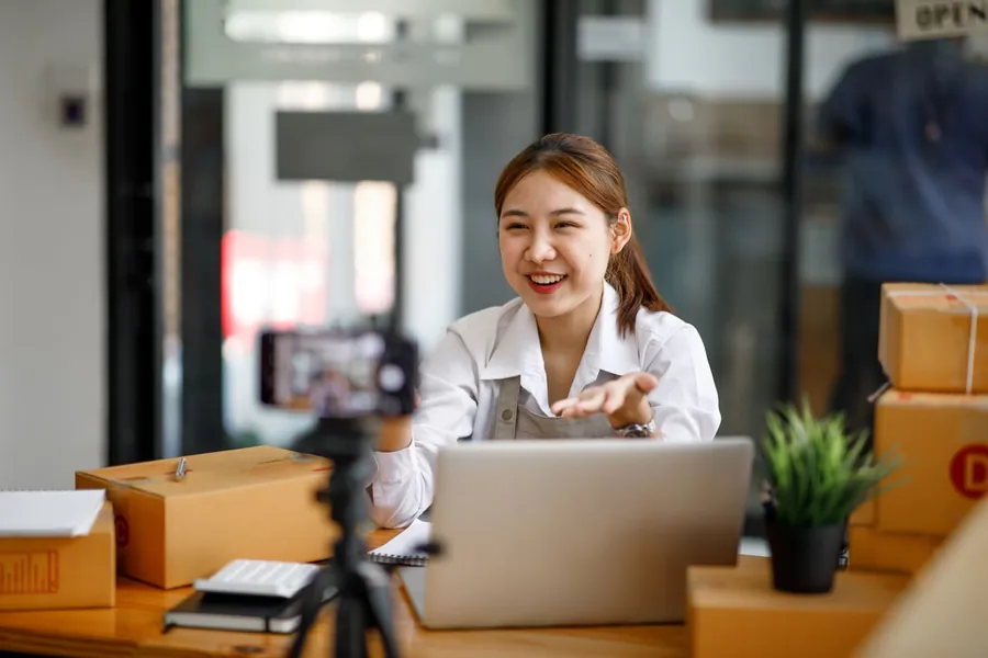 Seorang wanita tersenyum semasa membuat pembentangan daripada laptopnya